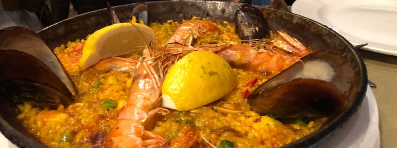 Fotografia ravvicinata paella spagnola con limone gamberi e cozze