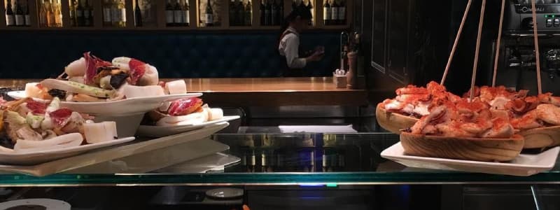 Fotografia di due piatti di tapas spagnole su un bancone in vetro in un locale