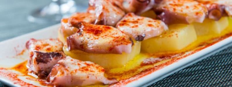 Fotografia ravvicinata di tapas spagnole condite in fila su un piatto